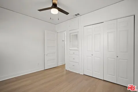 a view of an empty room and chandelier fan