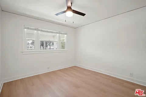 a view of a room with wooden floor and a ceiling fan