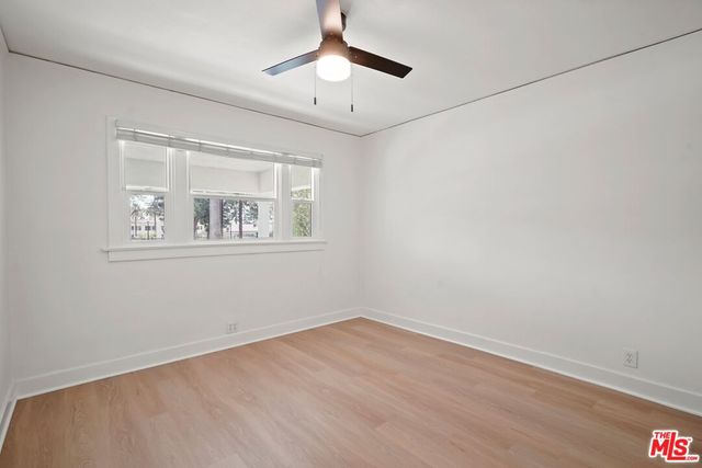 a view of a room with wooden floor and a ceiling fan