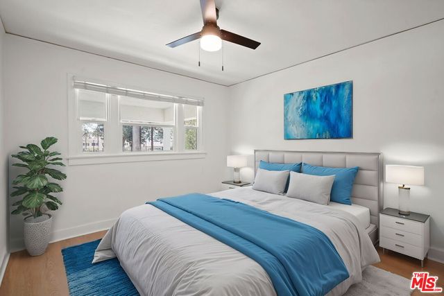 a bedroom with bed and a potted plant