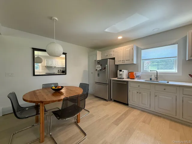 a kitchen with stainless steel appliances kitchen island granite countertop a sink a refrigerator and chairs