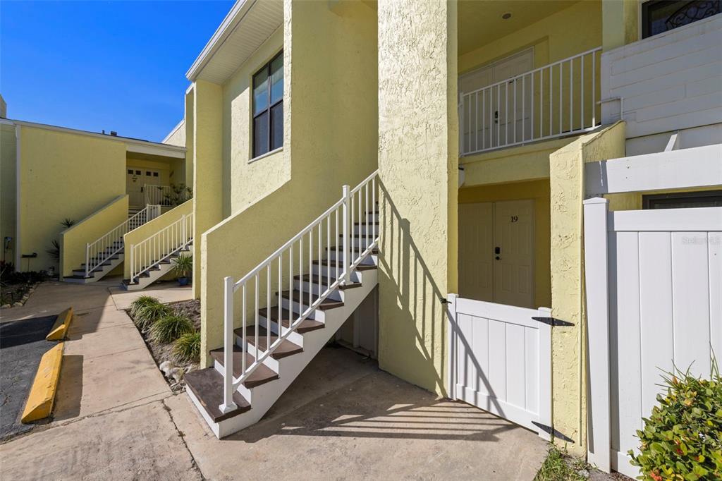 1 Windrush Boulevard, Unit 19 Indian Rocks Beach, FL 33785 - Photo 2 of 52 a view of a balcony with wooden floor and fence
