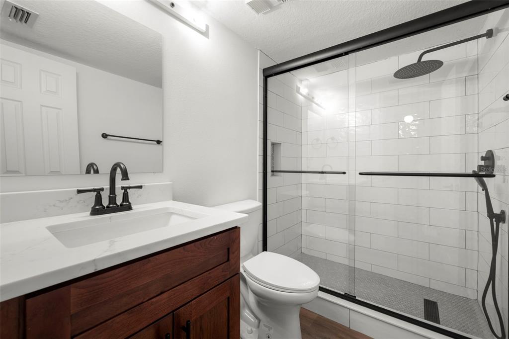 1 Windrush Boulevard, Unit 19 Indian Rocks Beach, FL 33785 - Photo 29 of 52 a bathroom with a sink mirror toilet and shower