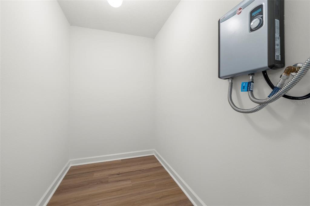 1 Windrush Boulevard, Unit 19 Indian Rocks Beach, FL 33785 - Photo 30 of 52 a view of a small space with wooden floor and mirror