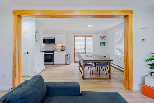 a living room with furniture a flat screen tv and kitchen view