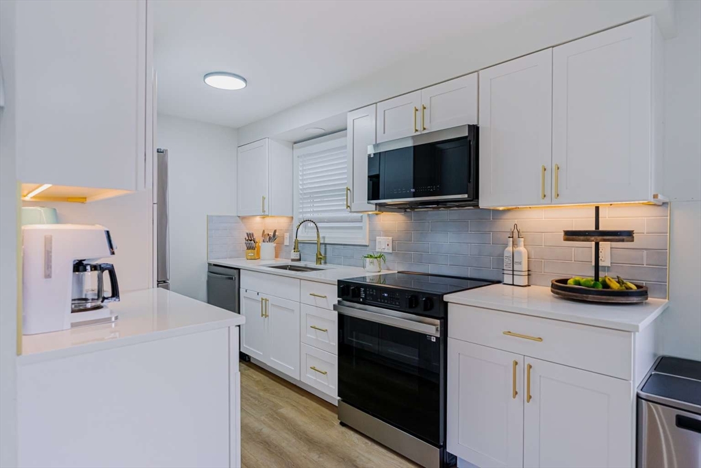 27 Silver Road, Unit 27 Everett, MA 02149 - Photo 2 of 42 a kitchen with granite countertop a sink stove and cabinets