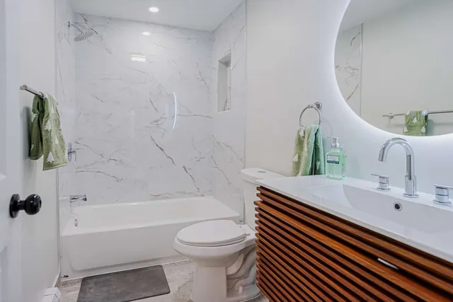 a bathroom with a sink a toilet and shower