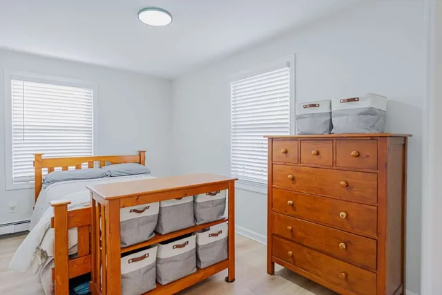a bedroom with a dresser and a window