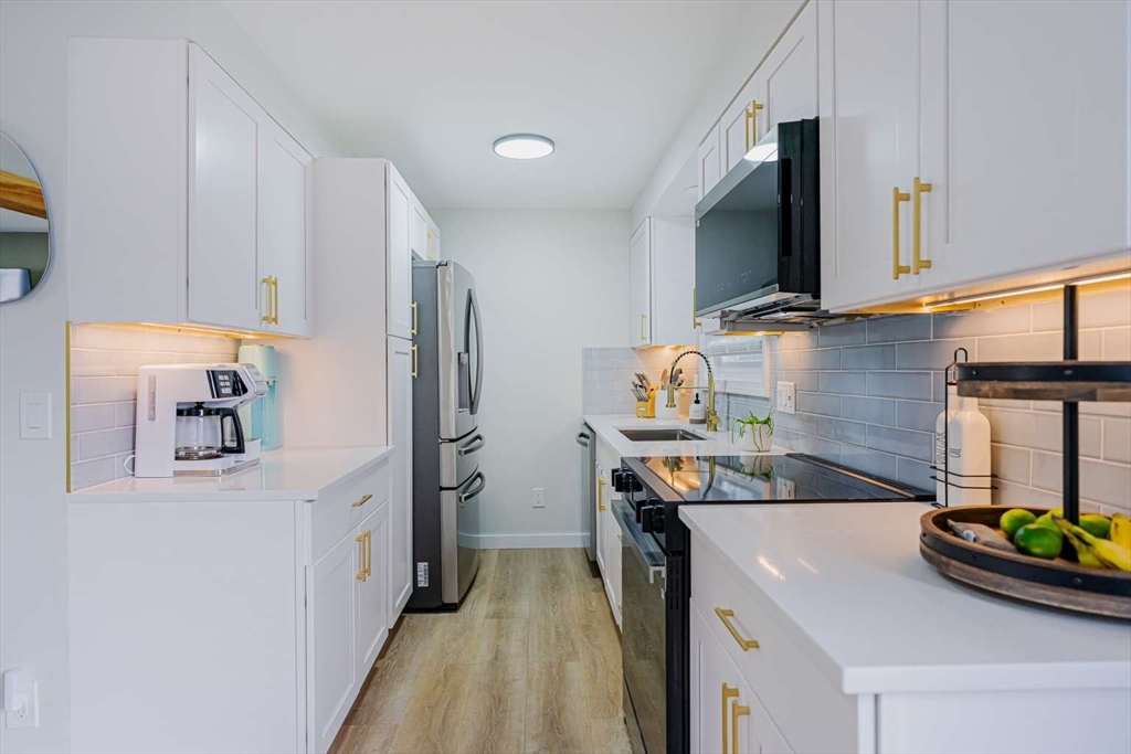 27 Silver Road, Unit 27 Everett, MA 02149 - Photo 6 of 42 a kitchen with stainless steel appliances a sink stove and refrigerator