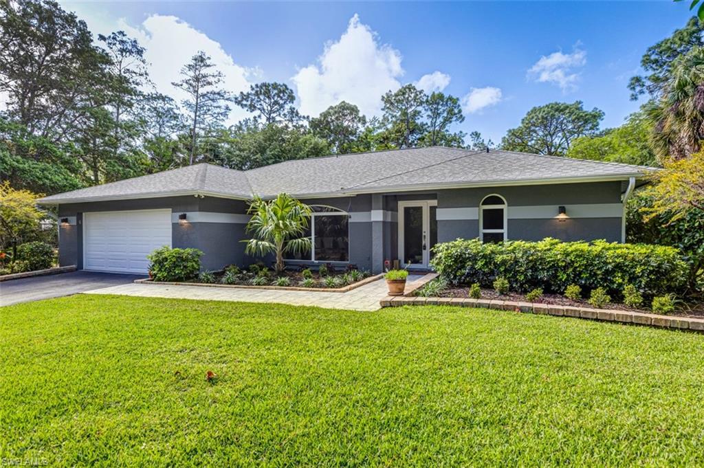 4710 15th Avenue Southwest Naples, FL 34116 - Photo 3 of 49 a front view of a house with a yard and garage