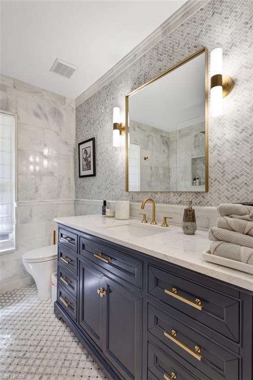 4710 15th Avenue Southwest Naples, FL 34116 - Photo 35 of 49 a spacious bathroom with a granite countertop double vanity sink a mirror and a toilet