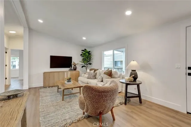 a living room with furniture a flat screen tv and a table