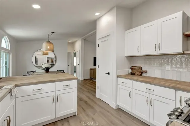 a kitchen with white cabinets and sink