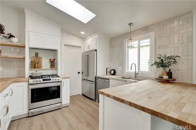 a kitchen with stainless steel appliances granite countertop a stove a sink and a refrigerator