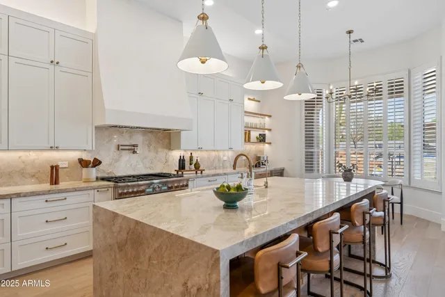 a kitchen with sink a stove and chairs