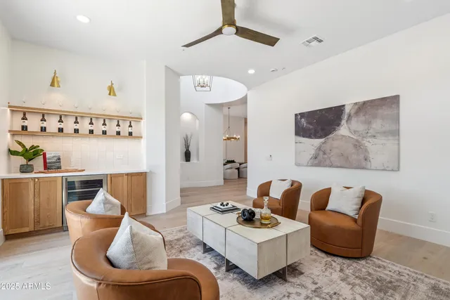 a living room with furniture a large window and a chandelier