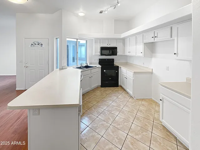 a large white kitchen with a large window