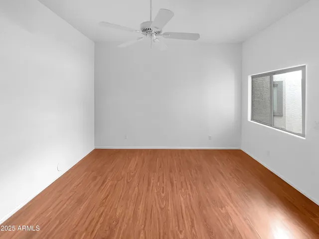 a view of a big room with wooden floor and an entryway