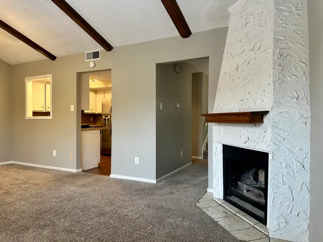 an empty room with fireplace and wooden floor
