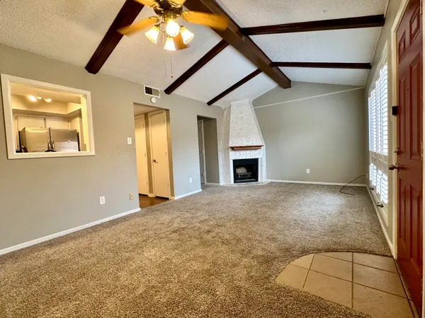 an empty room with windows and fireplace
