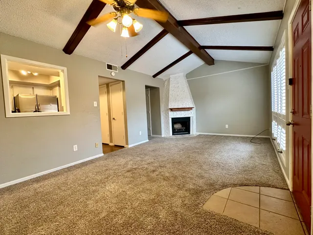 an empty room with windows and fireplace