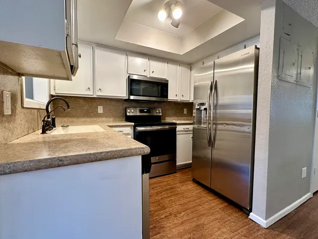 a kitchen with kitchen island granite countertop a sink stainless steel appliances and refrigerator