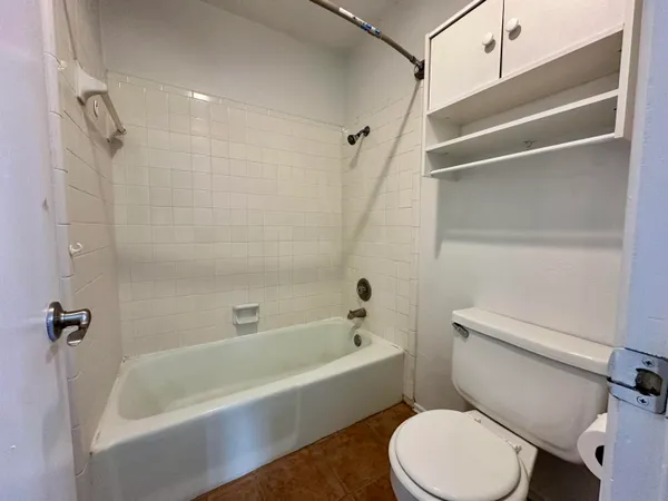 a white toilet sitting next to a bath tub