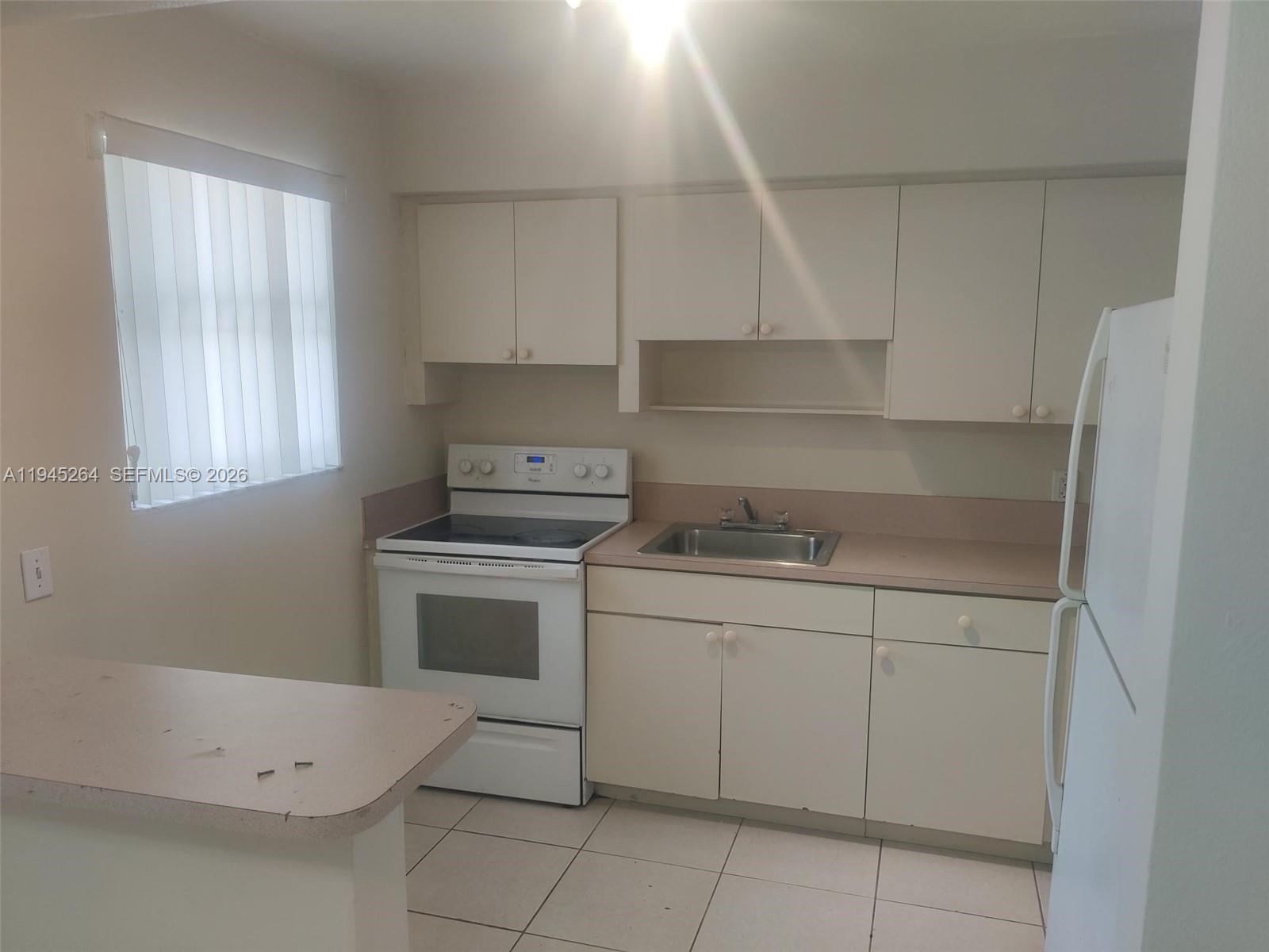 844 Southwest 10th Street Hallandale Beach, FL 33009 - Photo 16 of 18 a kitchen with a sink cabinets and appliances