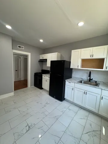 a large kitchen with a refrigerator a sink dishwasher and a stove