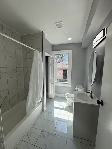 a bathroom with a tub sink and mirror