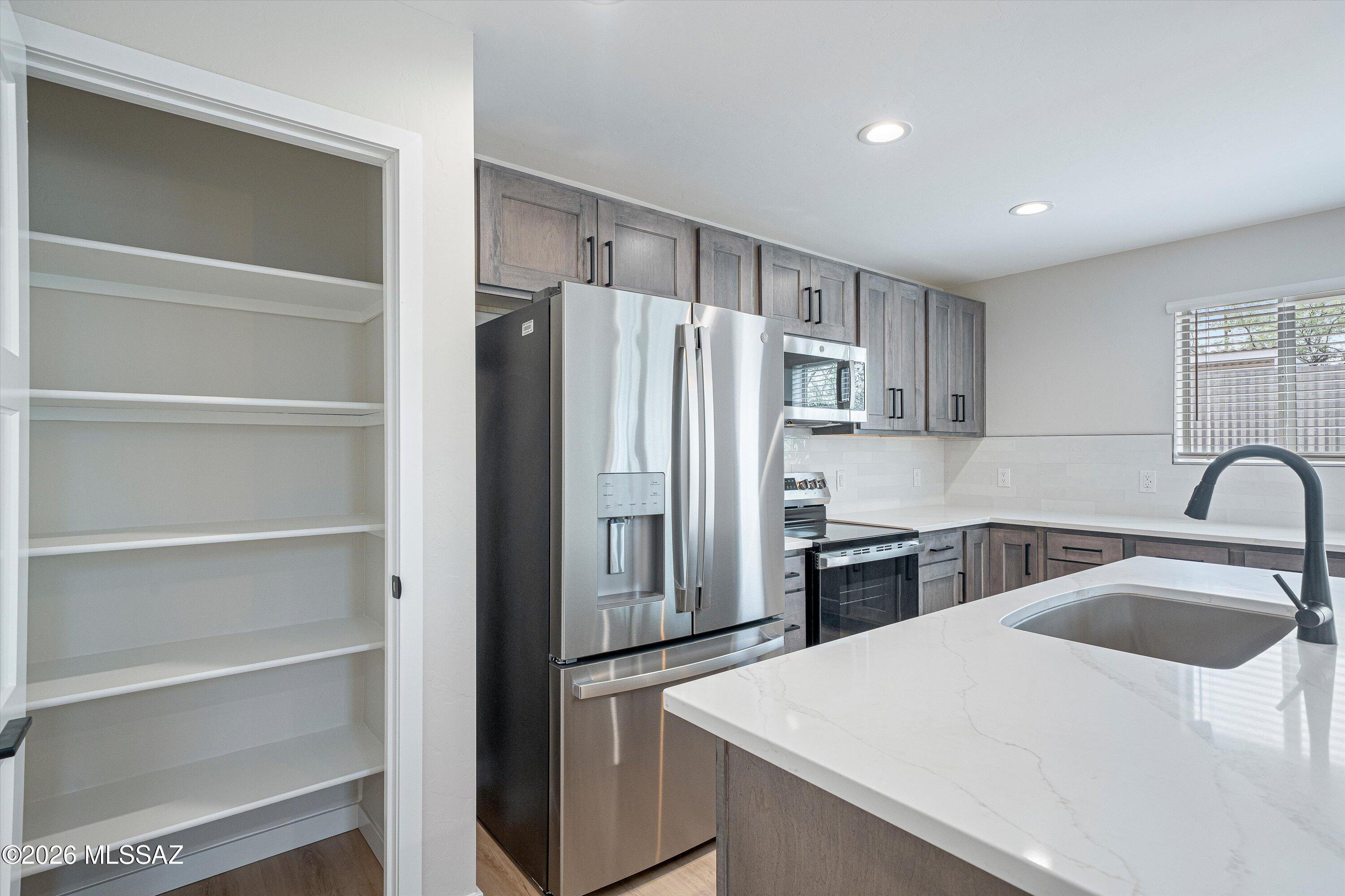 739 North Queen Avenue, Unit 2 Tucson, AZ 85705 - Photo 3 of 28 a kitchen with a refrigerator sink and cabinets