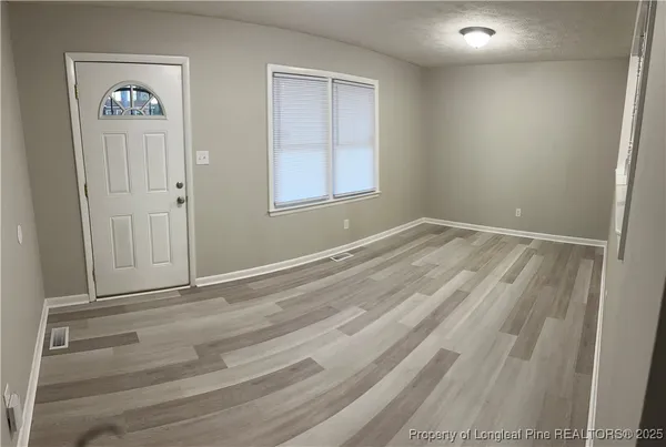 an empty room with windows and closet