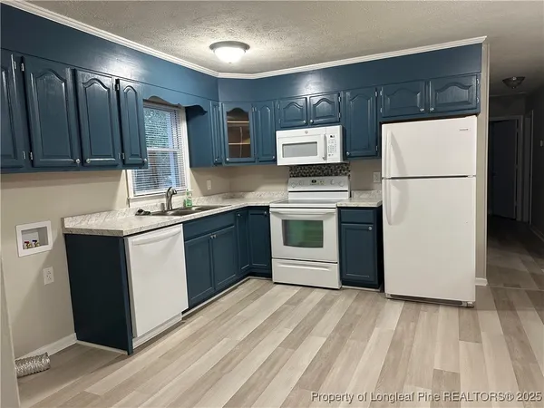 a kitchen with a sink appliances and cabinets