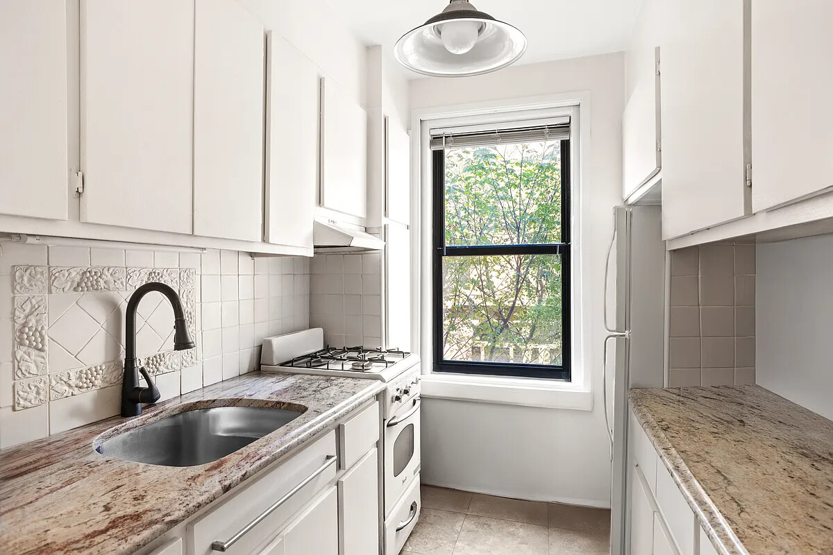 336 West End Avenue, Unit 3D Manhattan, NY 10023 - Photo 8 of 18 a kitchen with granite countertop a sink and a window