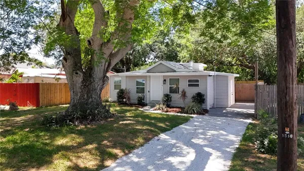 a front view of a house with a garden and trees