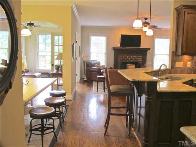 907 Shelley Road Raleigh, NC 27609 - Photo 10 of 23 a dining room with furniture a fireplace and wooden floor