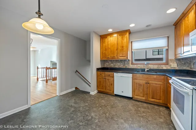 a kitchen with granite countertop a sink and a stove top oven
