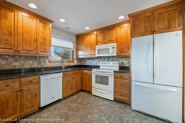 a kitchen with stainless steel appliances granite countertop a refrigerator sink and cabinets
