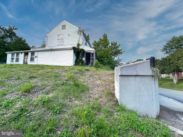 a view of a house with a yard and large tree