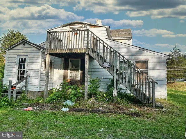 a view of a house with brick walls and a yard with plants