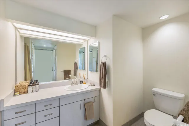 a bathroom with a toilet a sink a mirror and vanity