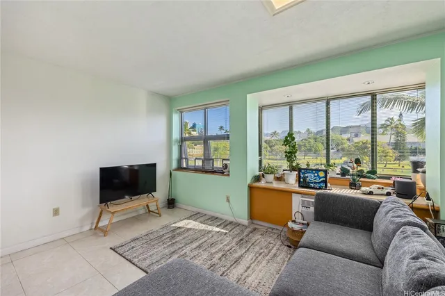 a living room with furniture a flat screen tv and a floor to ceiling window