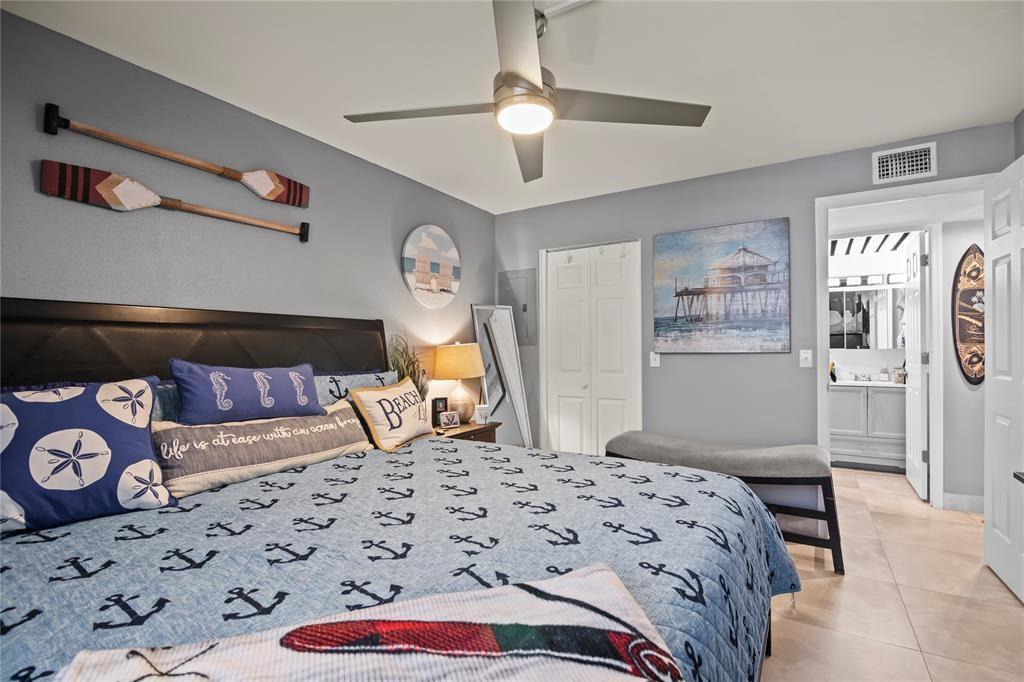 352 Saxony Trail, Unit 352 Delray Beach, FL 33446 - Photo 12 of 17 a bedroom with a bed and a lamp on dresser