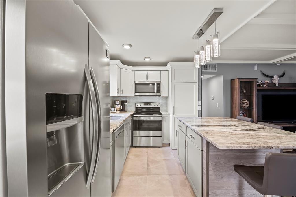 352 Saxony Trail, Unit 352 Delray Beach, FL 33446 - Photo 2 of 17 a kitchen with stainless steel appliances granite countertop a refrigerator a stove a sink and a refrigerator