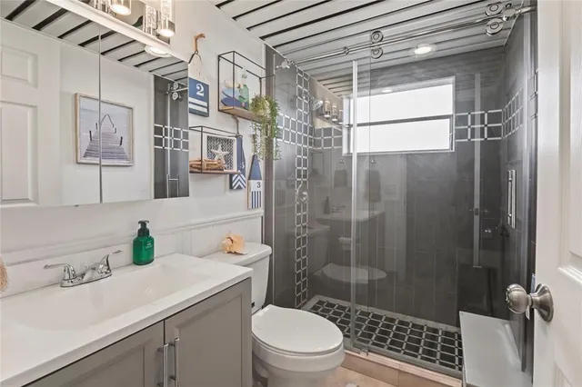 a bathroom with a sink a toilet and shower