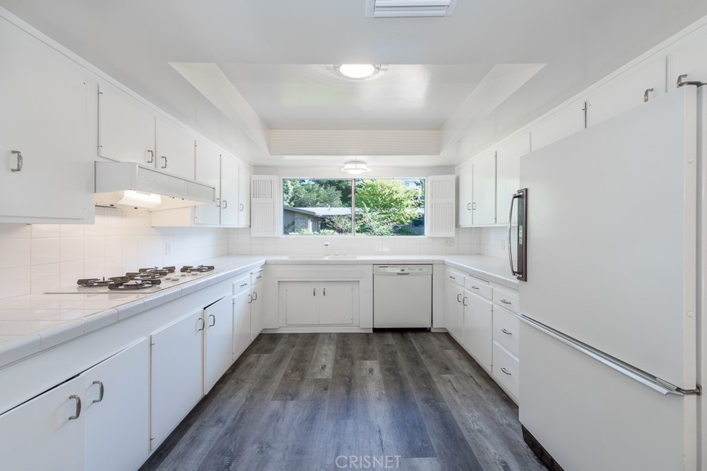 3949 Ballina Drive Encino, CA 91436 - Photo 12 of 31 a kitchen with a white stove a sink dishwasher and wooden floor