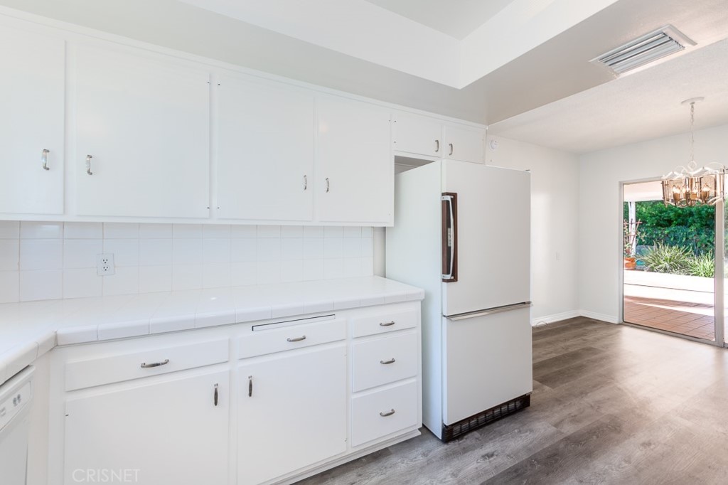 3949 Ballina Drive Encino, CA 91436 - Photo 13 of 31 a kitchen with white cabinets and refrigerator