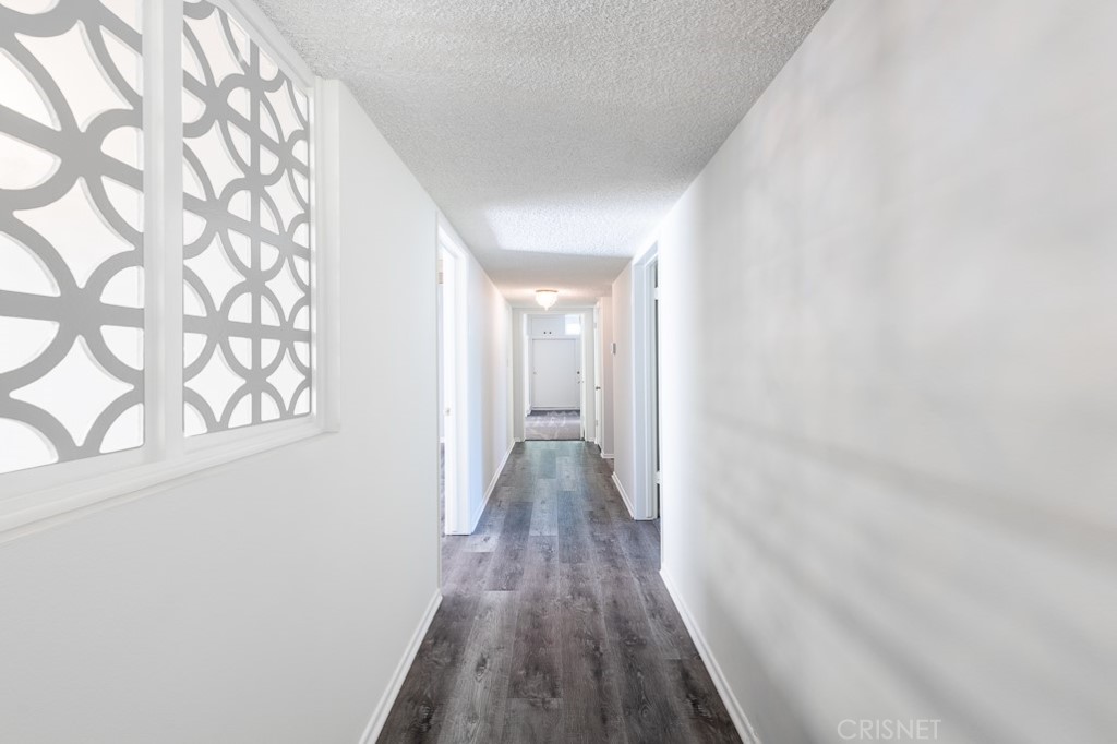 3949 Ballina Drive Encino, CA 91436 - Photo 14 of 31 a view of a hallway with wooden floor and a bathroom