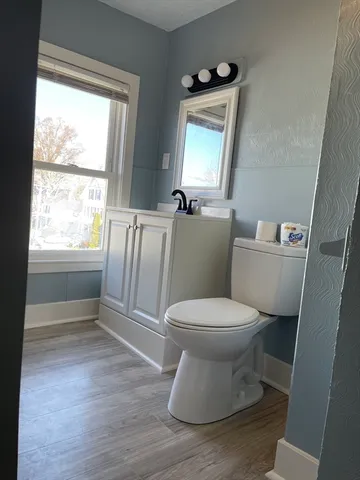 a white toilet sitting next to a window in a bathroom