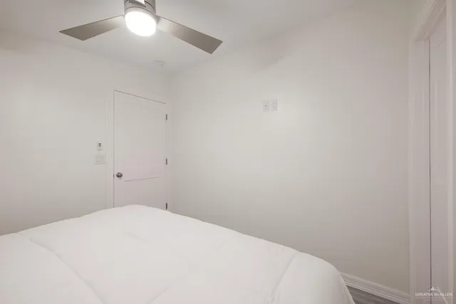 a bedroom with a bed and a fan